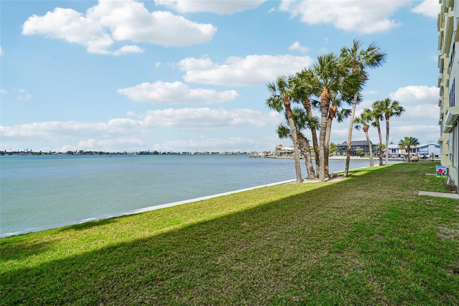 Community Waterfront Grounds – The beautifully maintained waterfront grounds provide an expansive grassy lawn framed by swaying palms and open water vistas — a peaceful retreat that sets this community apart and extends your living space well beyond your front door.