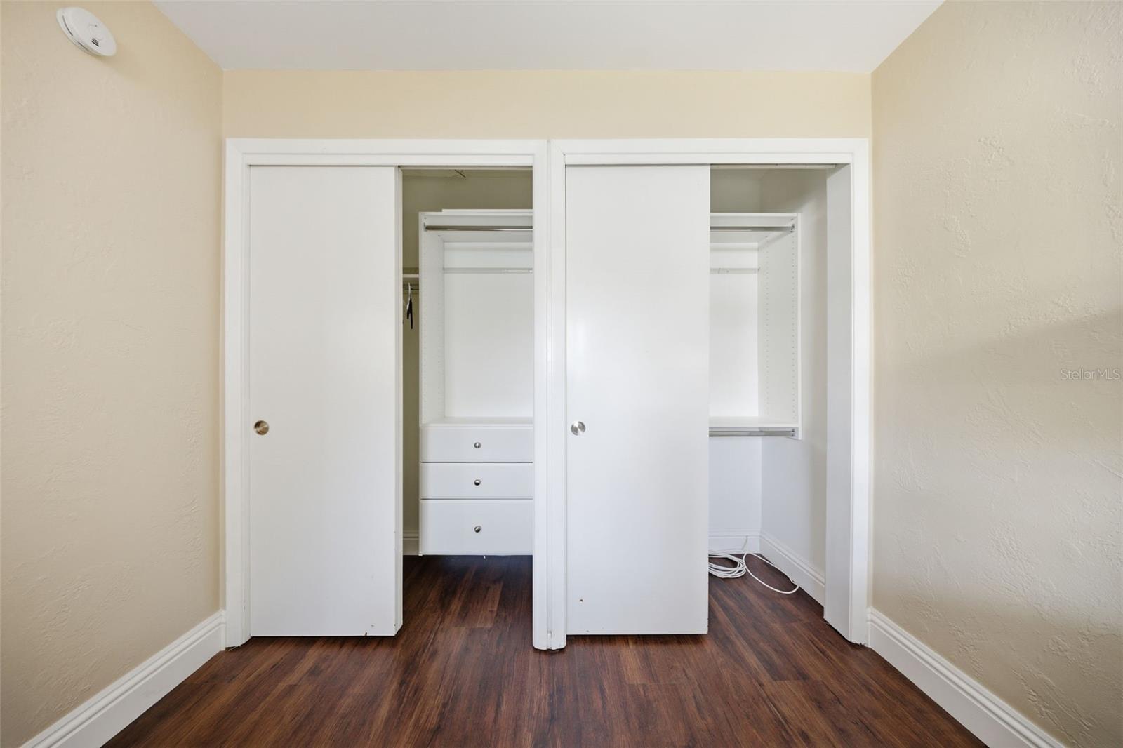 Primary bedroom double closets with built-in closet systems.