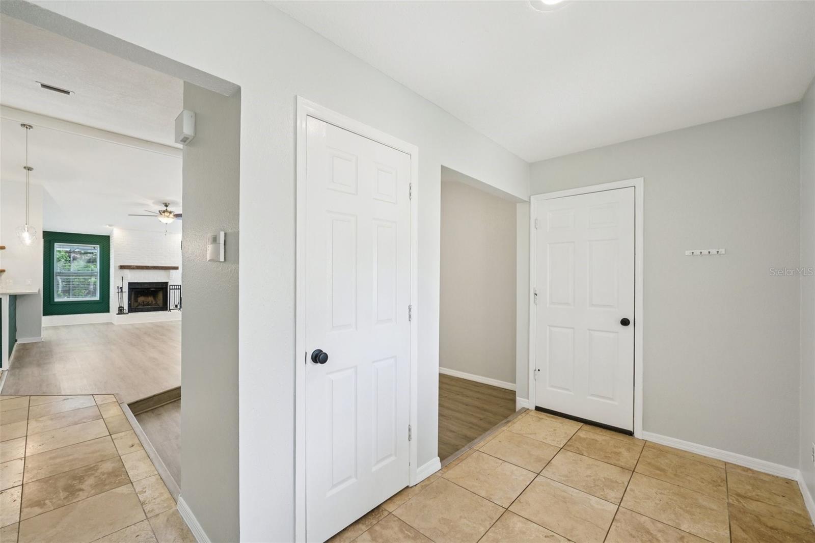 Foyer with travertine tile flooring that flows to the dining room and kitchen, closet and entry door from garage.