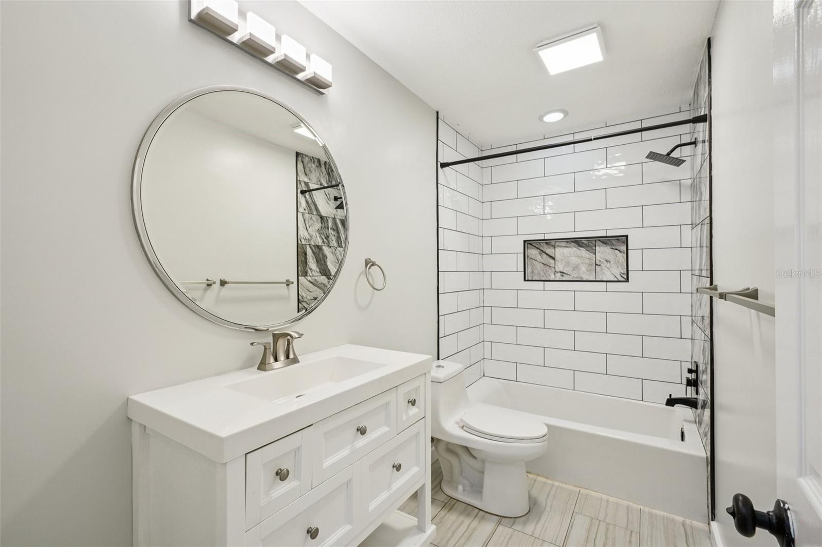 The second bathroom includes a tub/shower combination with large subway tile and a rain shower head.