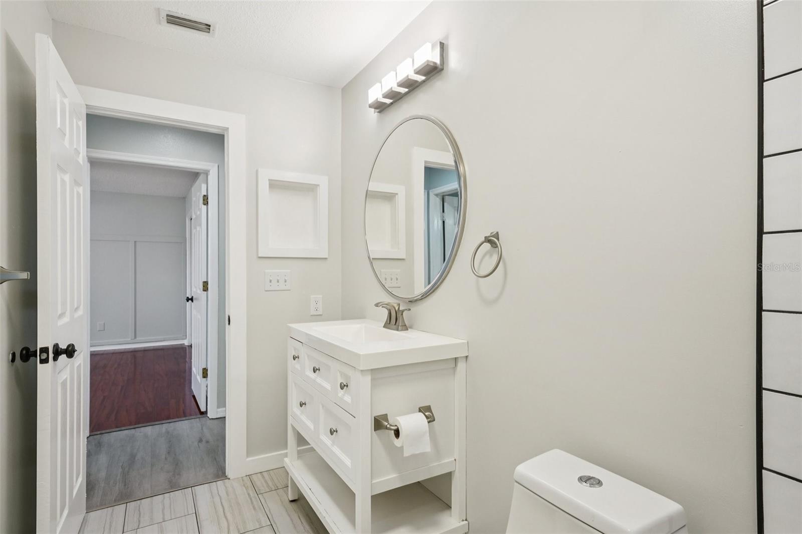The second bathroom includes a tub/shower combination with large subway tile and a rain shower head.