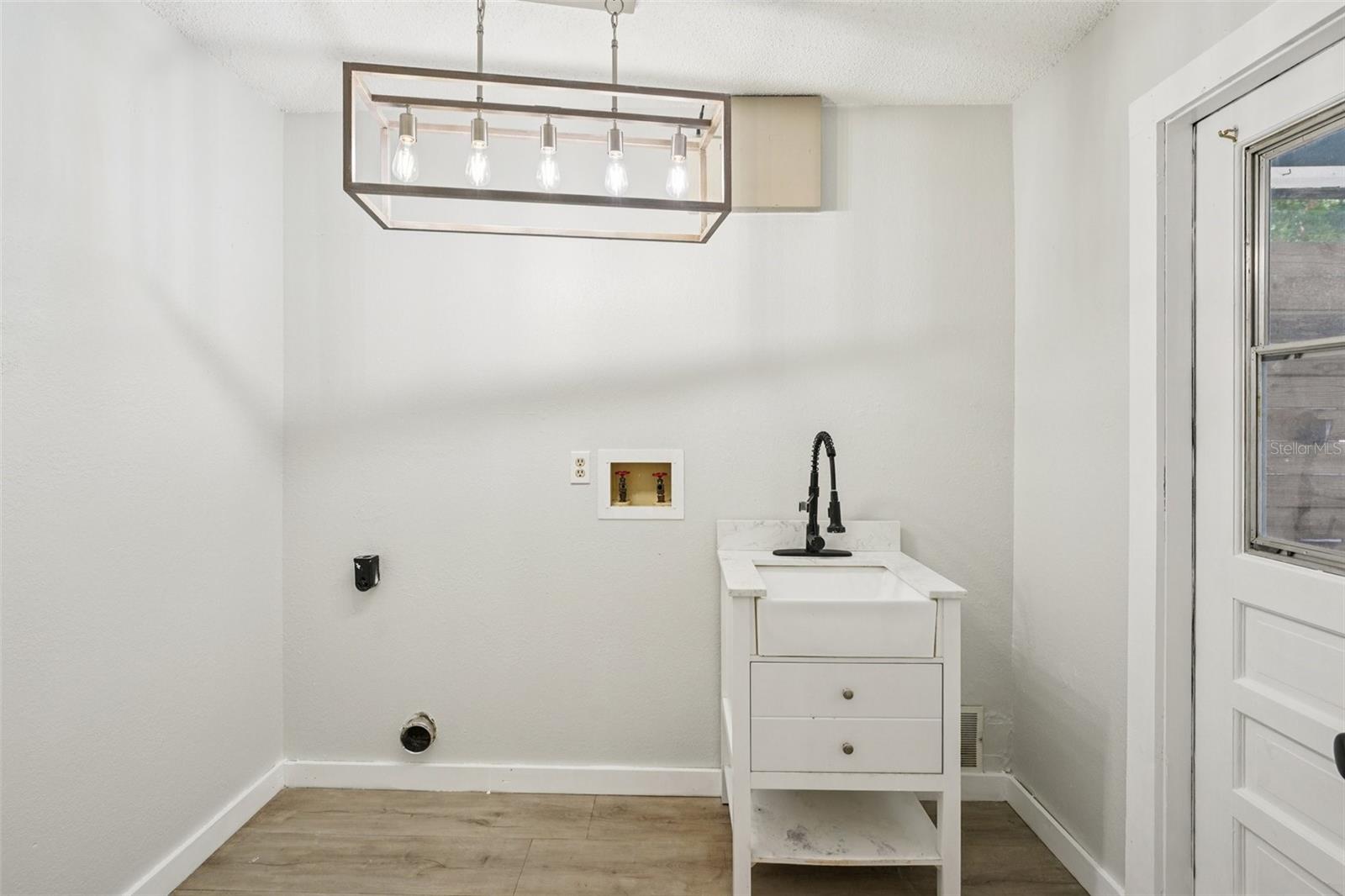Utility room off the kitchen with door out to back yard