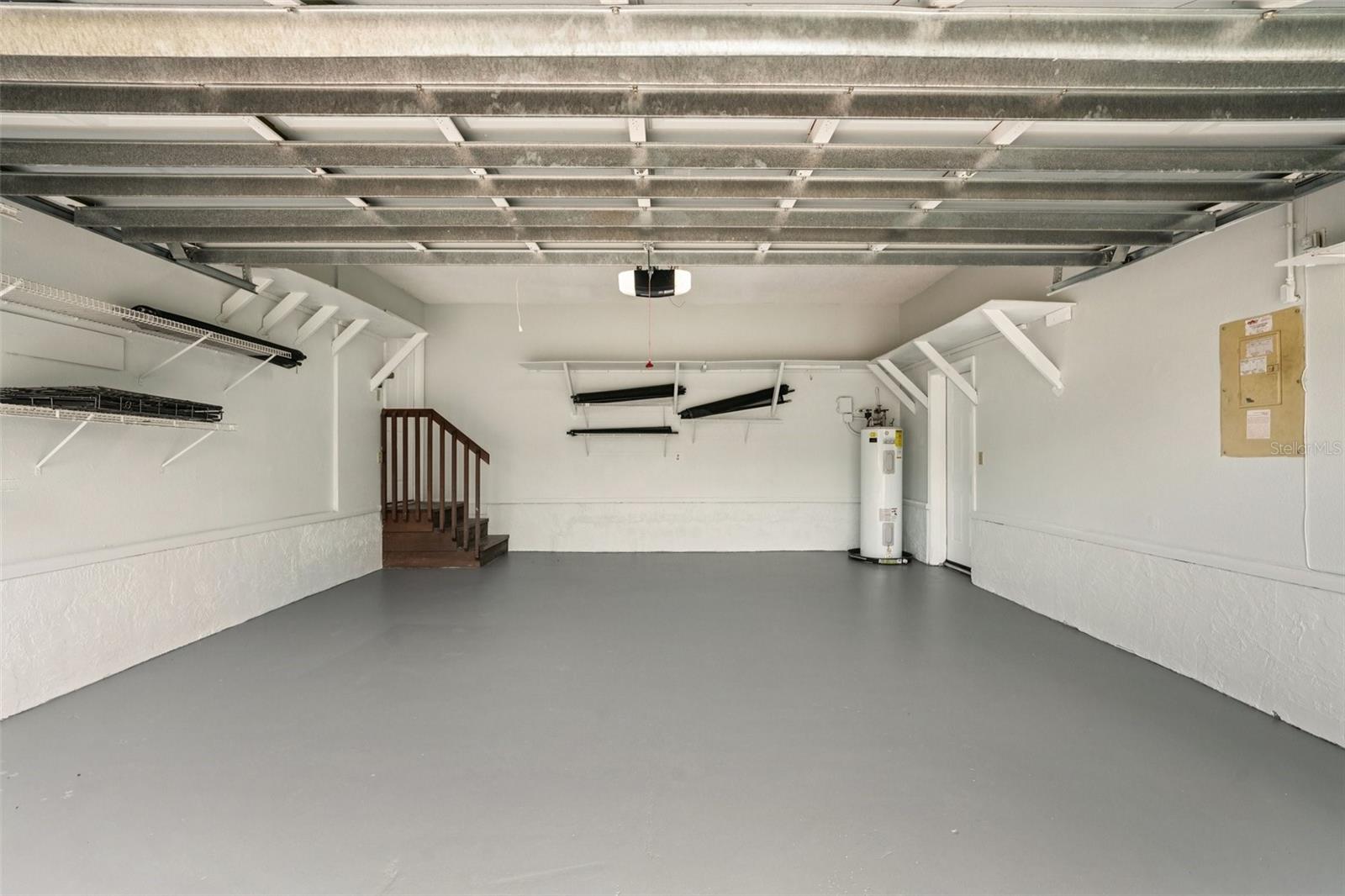 Neat and clean garage with newer flooring and added shelving.