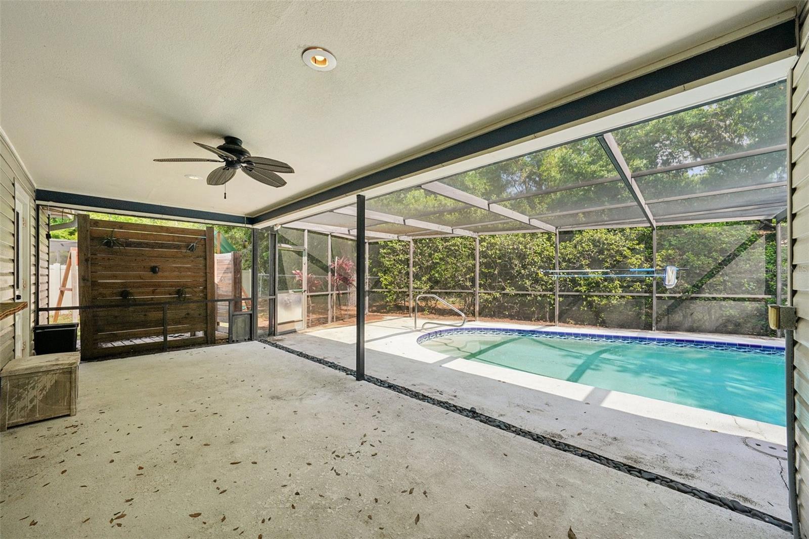 The screened-in pool area includes a covered area to sit and relax with a sparkling Pebble Tec pool to cool off in and enjoy the Florida weather.