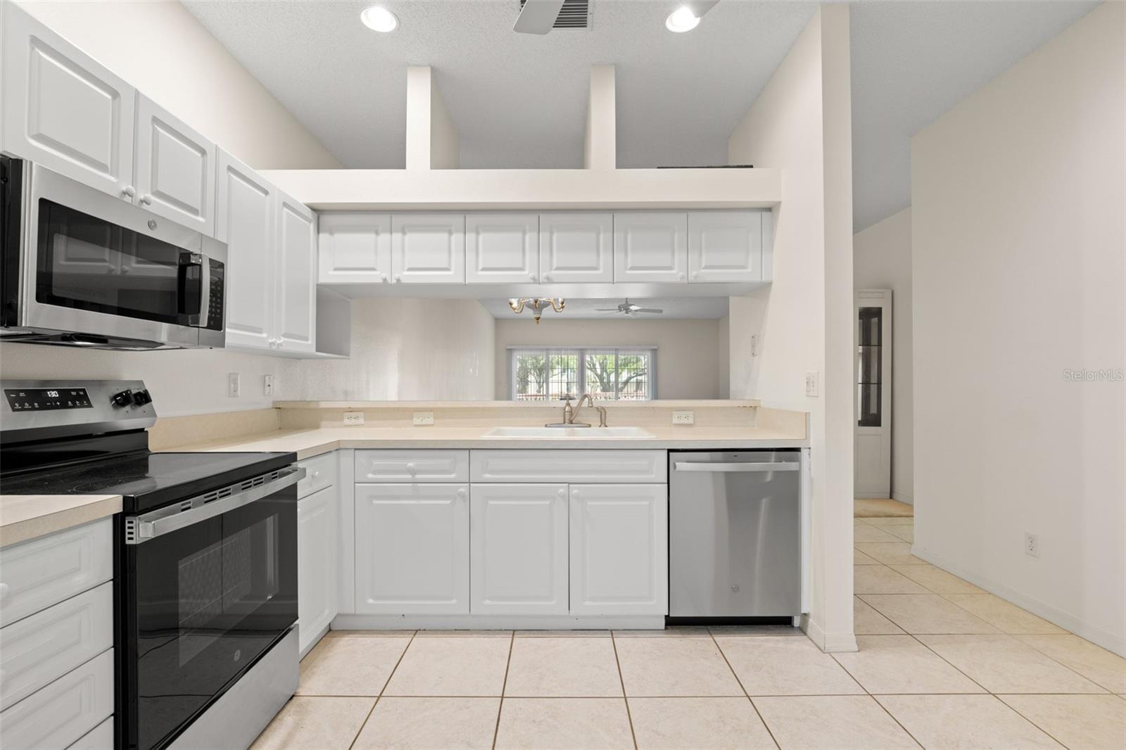 Functional kitchen with extended breakfast bar and pass-through to the living room, creating an open connection the to main living area.