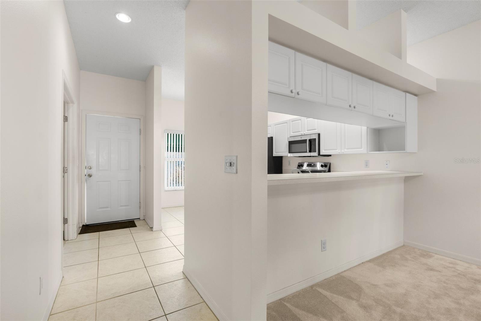 Defined foyer with tile flooring and a convenient pass-through to the kitchen, creating an open connection to the main living and dining areas.