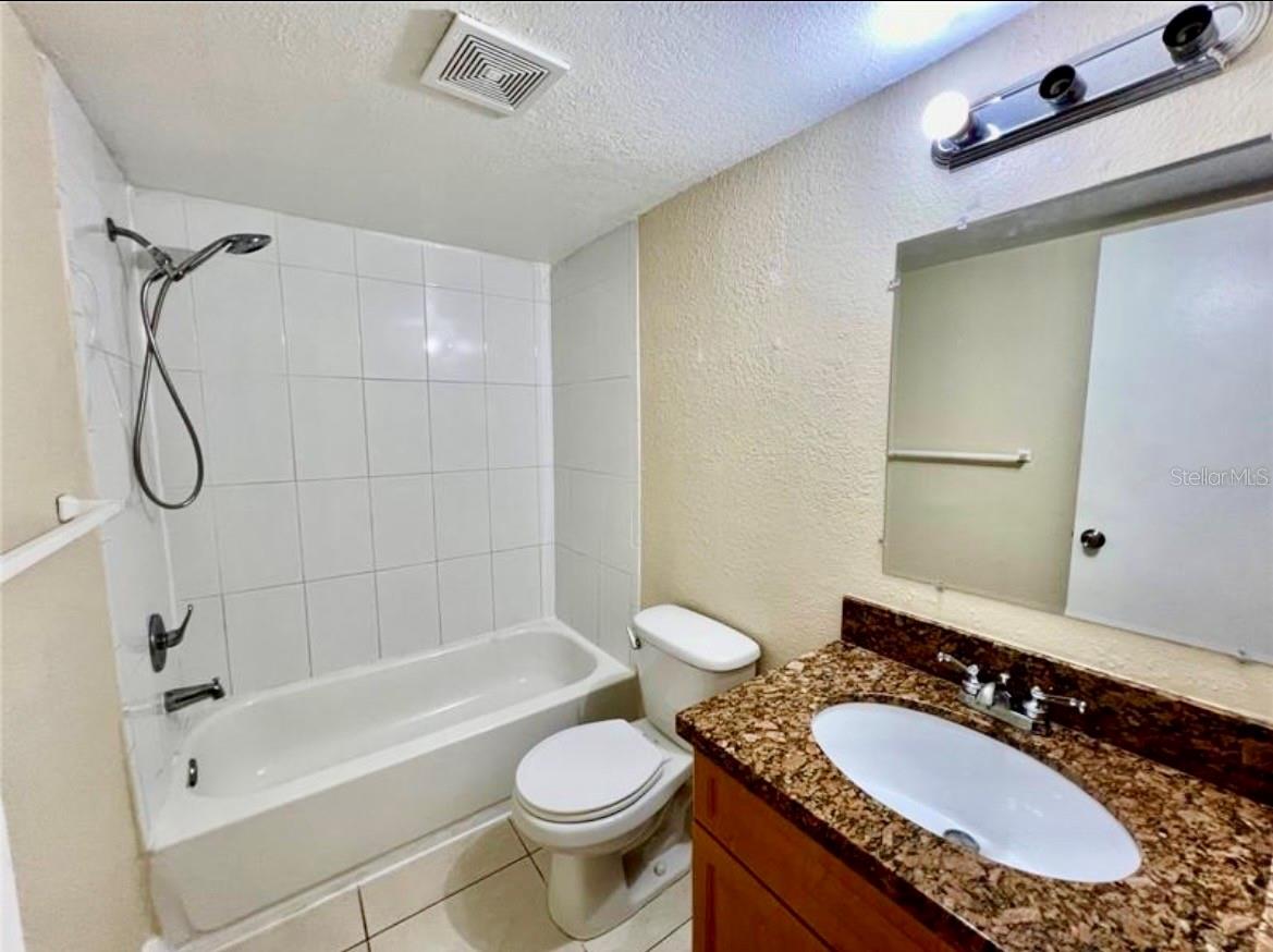 Tub and shower and matching granite countertop in bathroom
