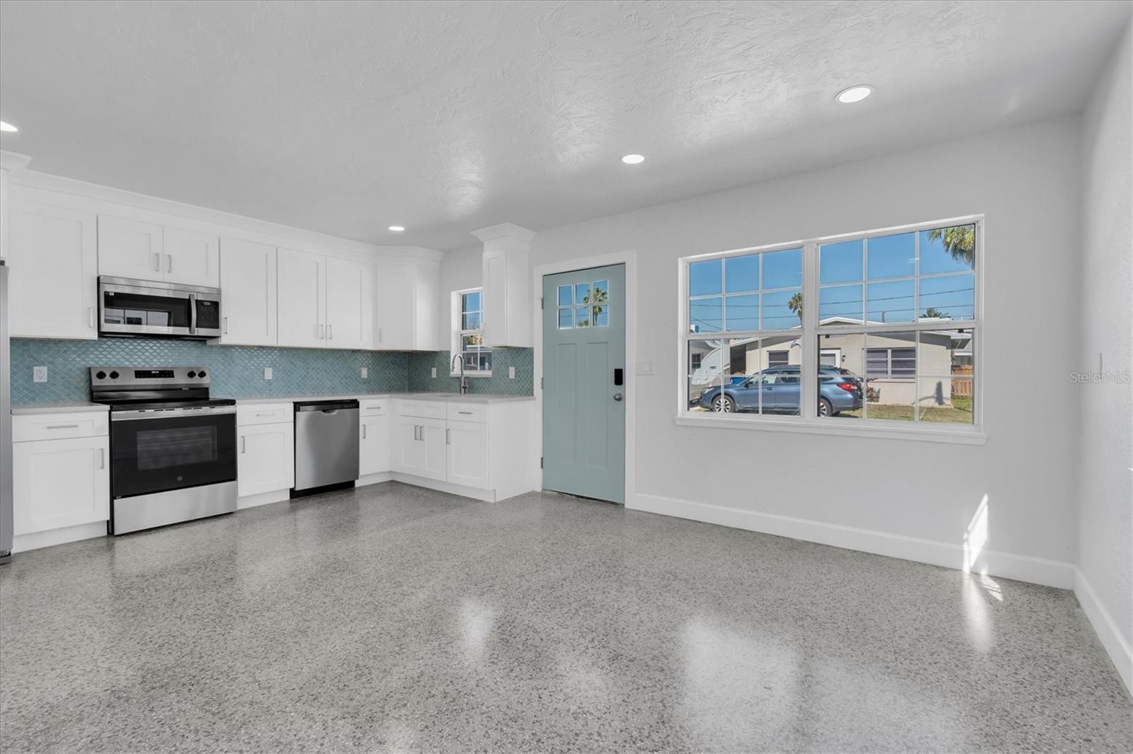 Newly Remodeled Kitchen with Stainless Steel Appliances, Tiled Backsplash, Recessed Lighting, White Cabinets, and Quartz Countertops - Left Side