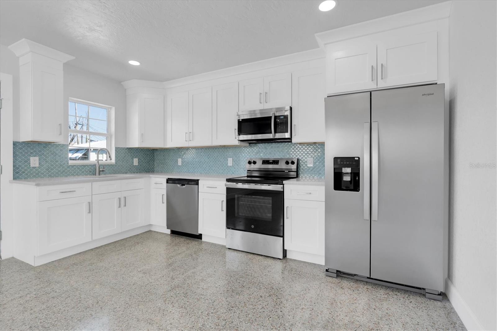 Newly Remodeled Kitchen with Stainless Steel Appliances, Tiled Backsplash, Recessed Lighting, White Cabinets, and Quartz Countertops - Right Side