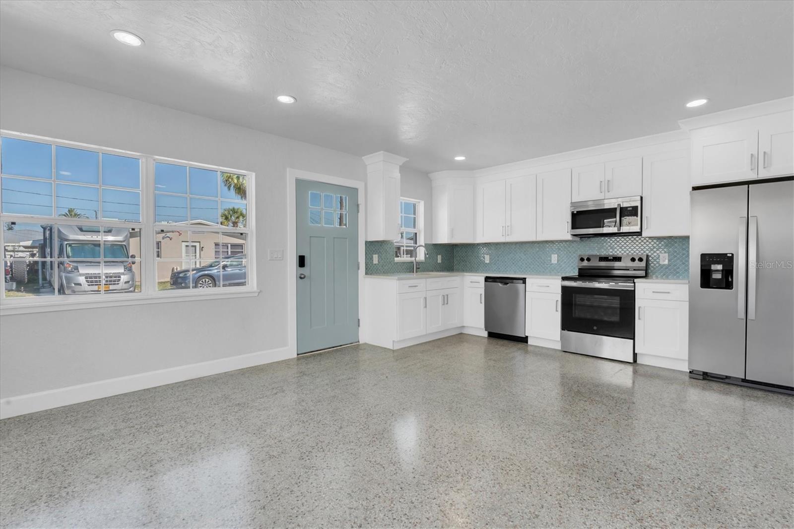 Newly Remodeled Kitchen with Stainless Steel Appliances, Tiled Backsplash, Recessed Lighting, White Cabinets, and Quartz Countertops - Right Side