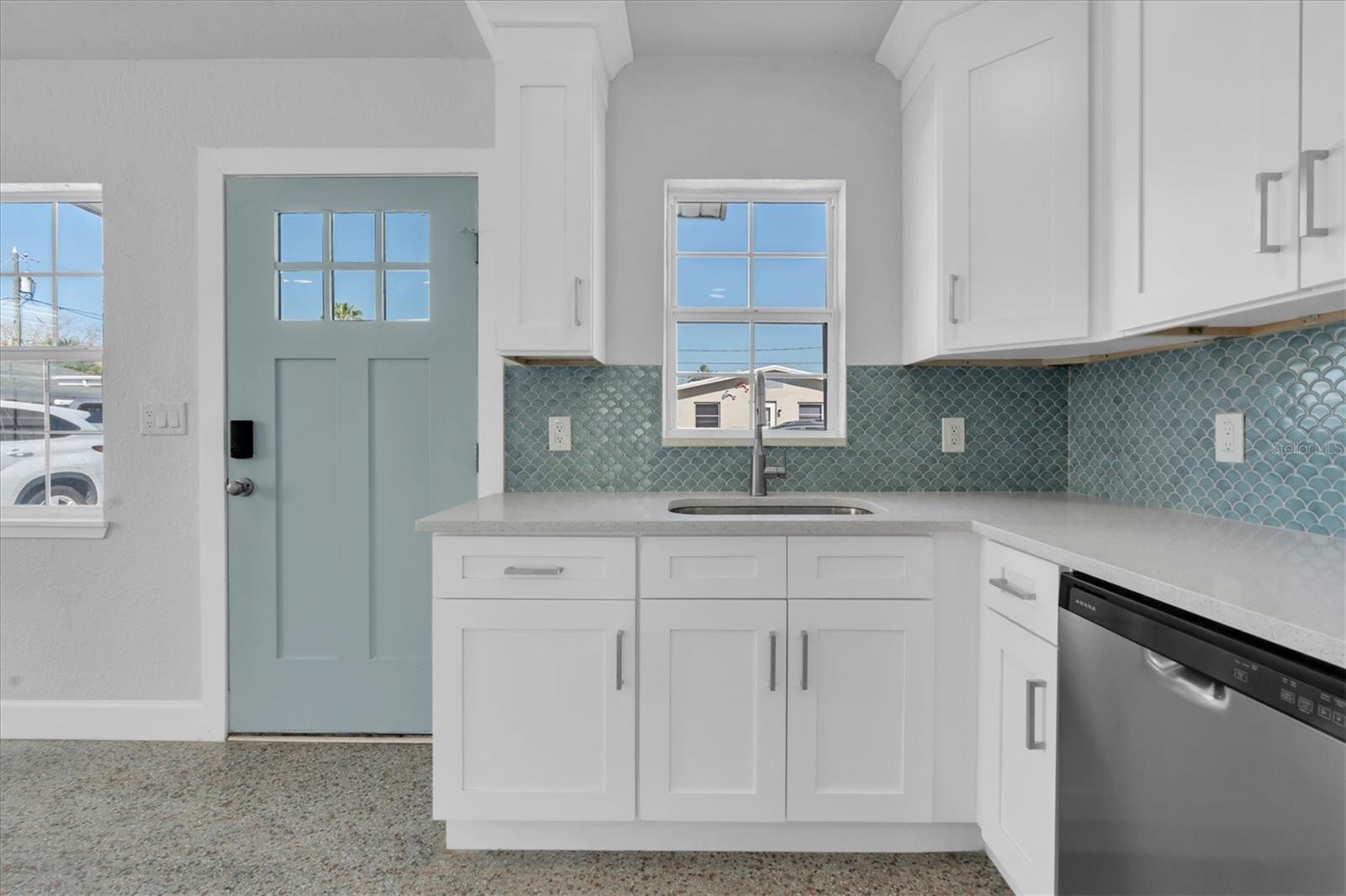 Newly Remodeled Kitchen with Stainless Steel Appliances, Tiled Backsplash, Recessed Lighting, White Cabinets, and Quartz Countertops and open to Living Area - Right Side