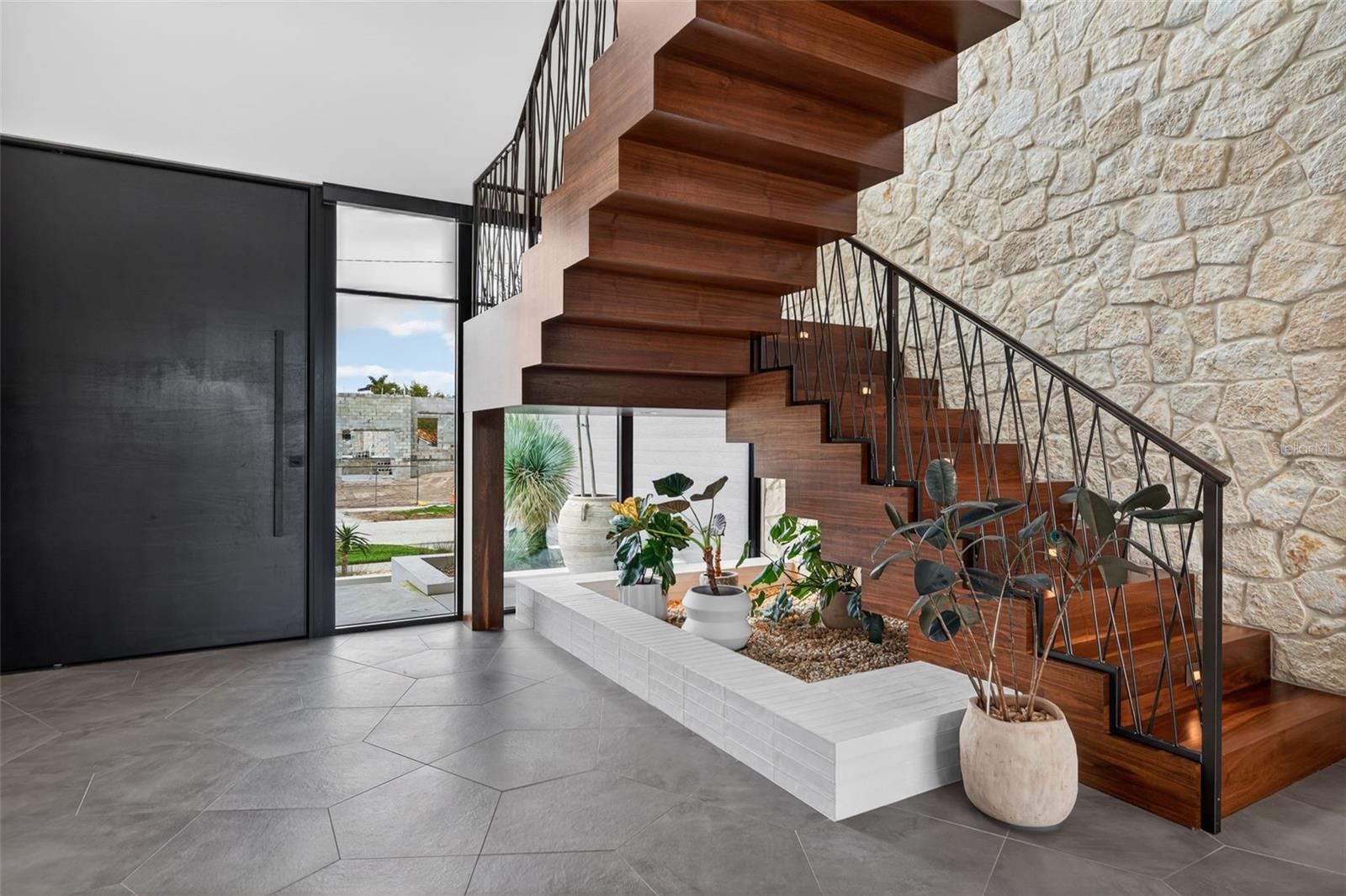 Custom Pivot door and solid walnut sawtooth staircase