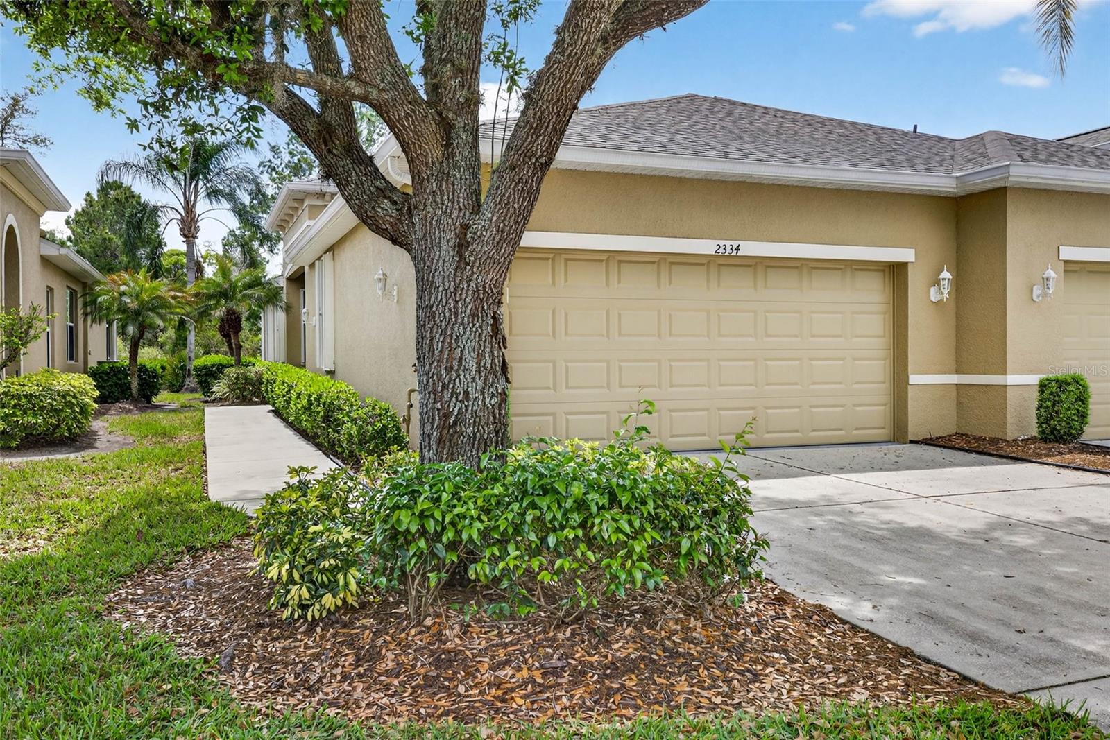 2 car garage with pathway along side of villa to entry.