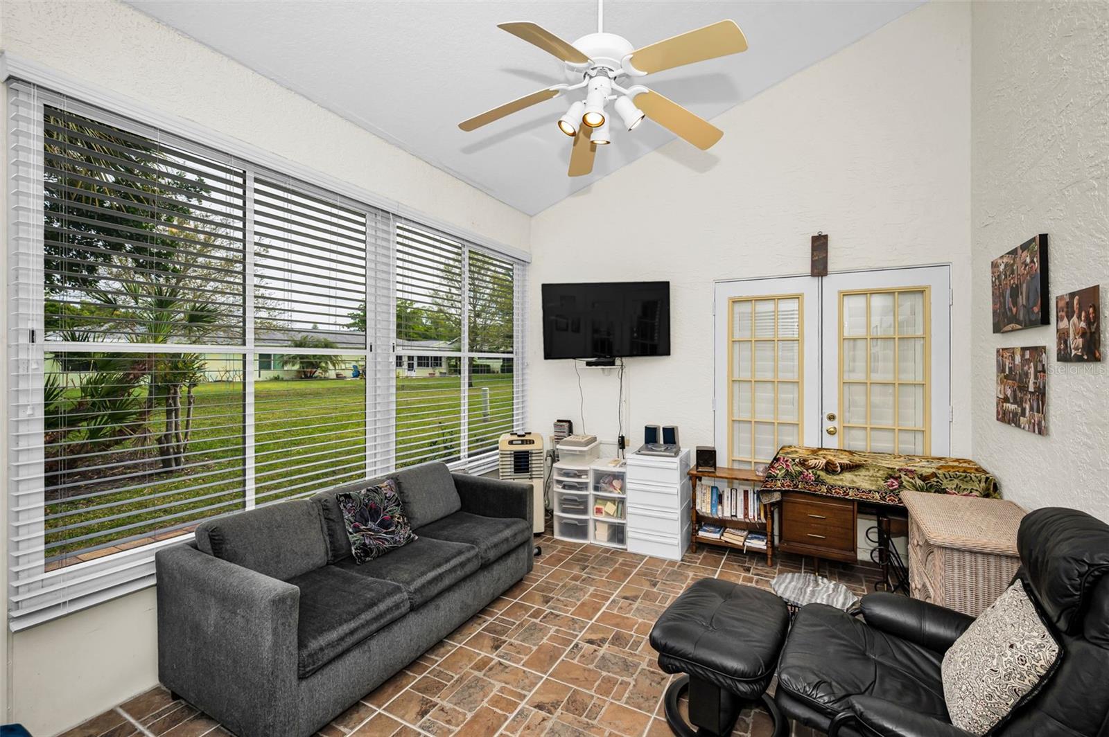 Enclosed Florida room with glass windows and brick tile floor