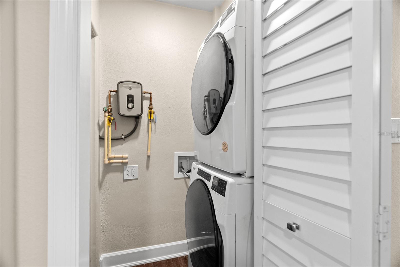 Indoor washer/dryer and a Rheem tankless hot water heater.