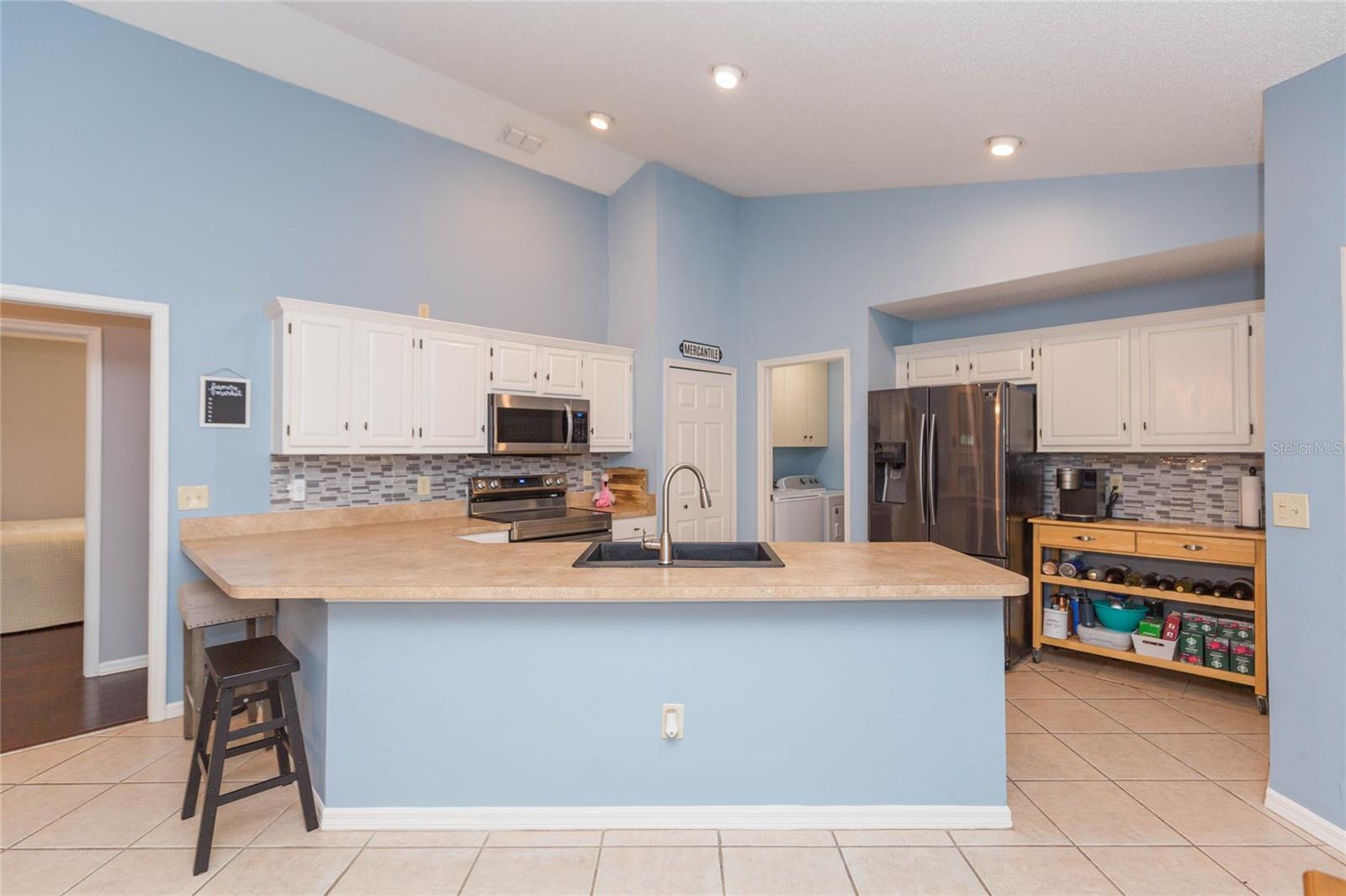 Open kitchen with crown molding, granite sink and newer stainless appliances, open to the great room