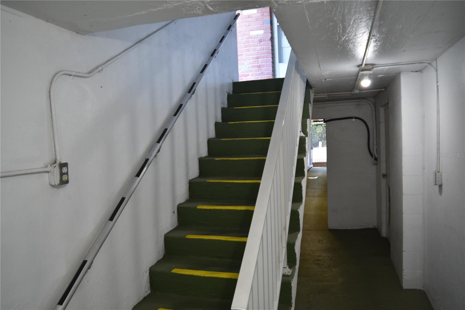 Steps leading from first floor to the hallway the leads to garages behind building