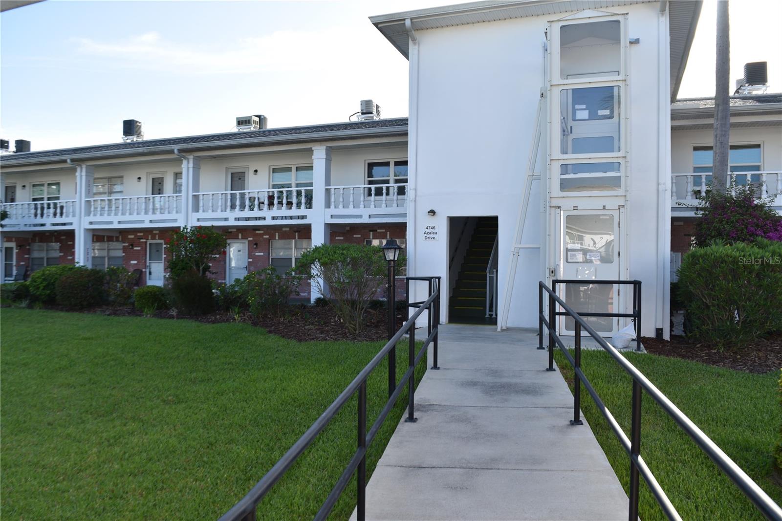 Walkway to elevator and steps to second story and downstairs to hall the leads to back ally with garages