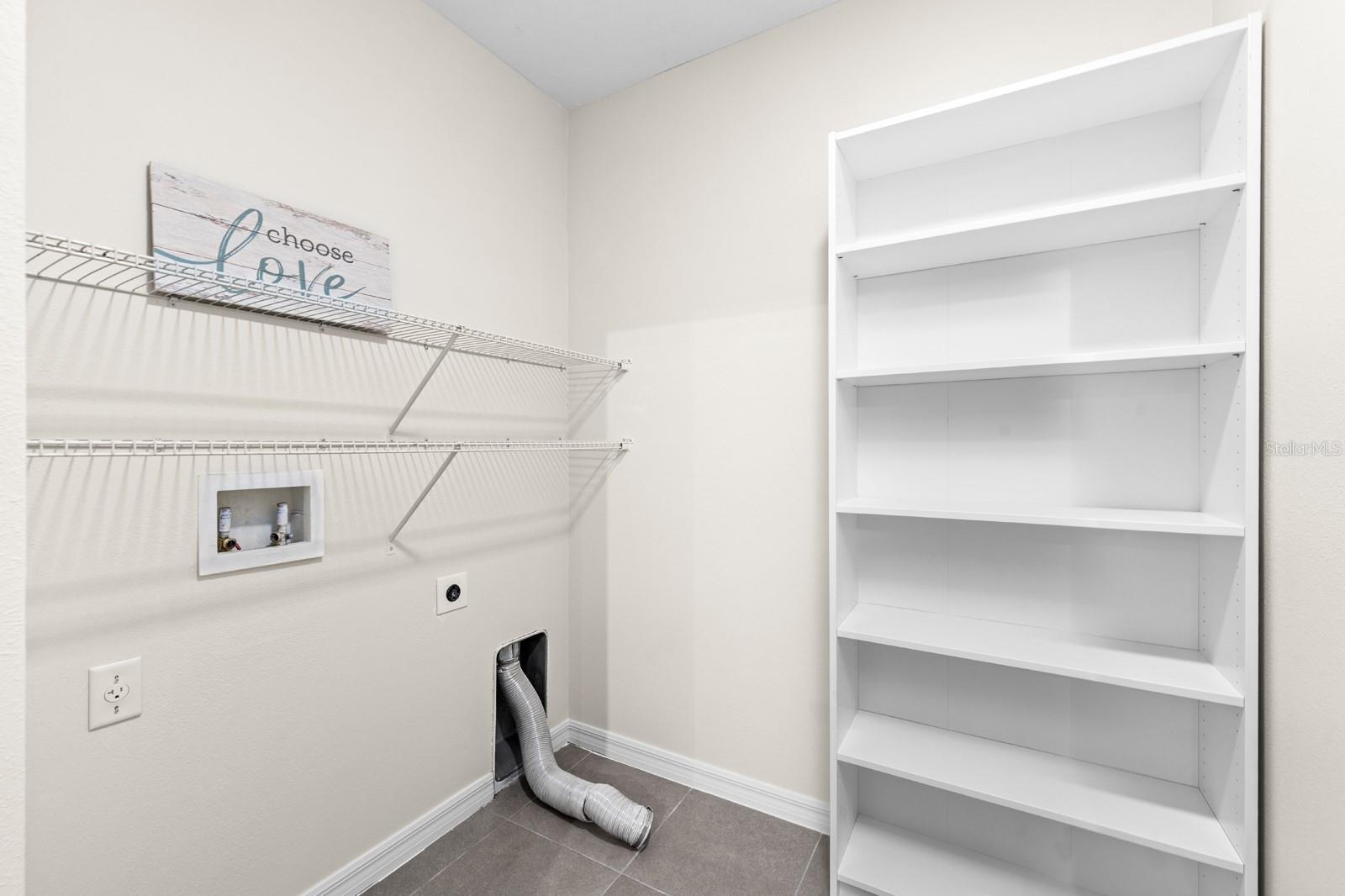 The laundry room is spacious and features brand new storage shelves.