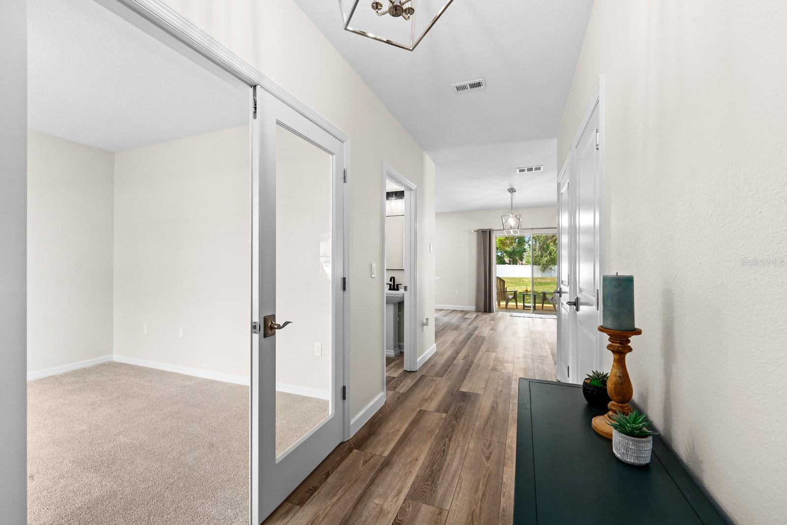 Just inside the front entrance, the bonus room with glass french doors is to the left.