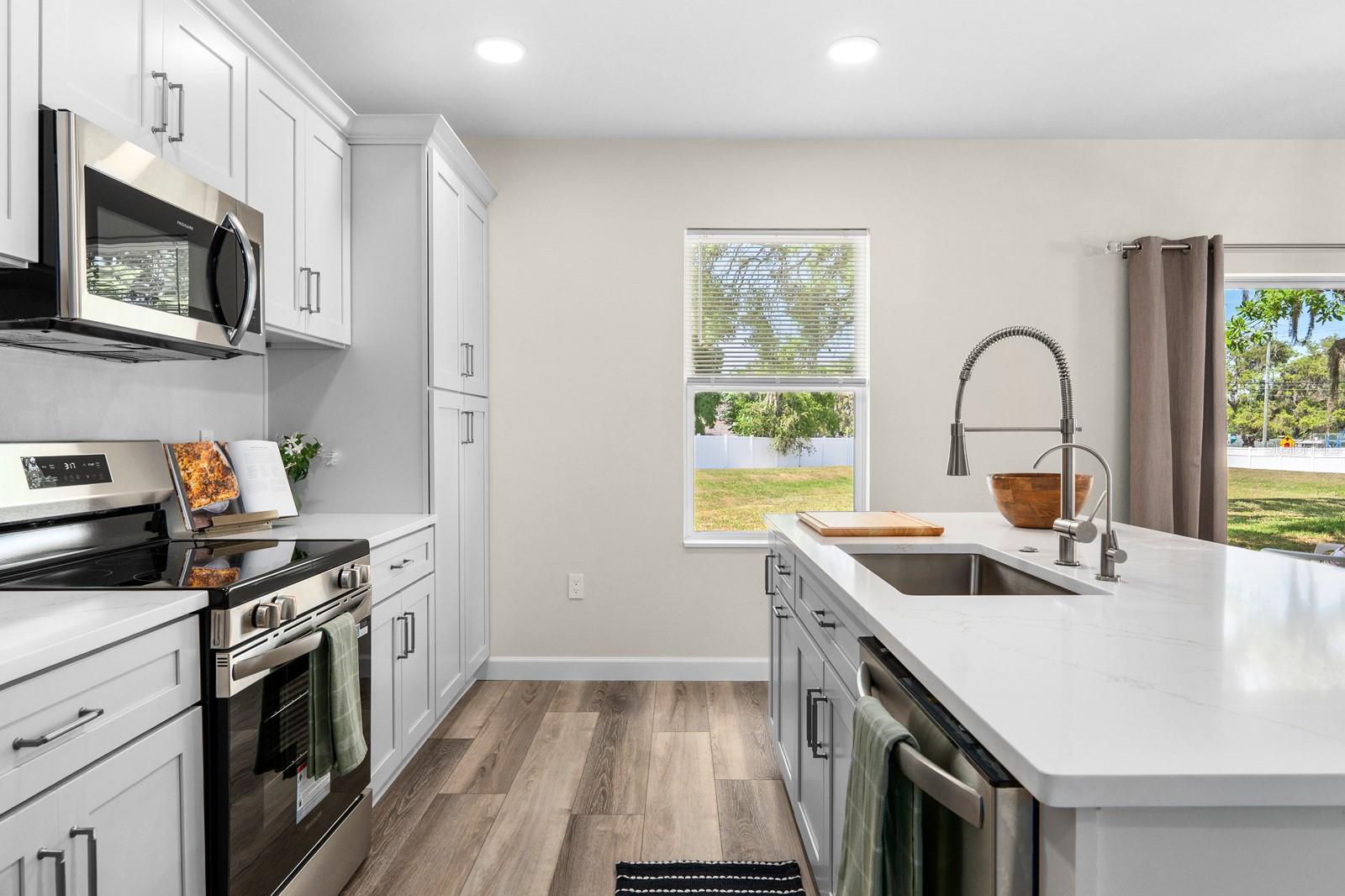 The kitchen has all new cabinets with the soft-close feature. The tall cabinet on the right replaced the smaller cabinets.  Quartz countertops, new stainless appliances, new sink and modern faucet, and a new water dispenser with a water filtration system under the sink.