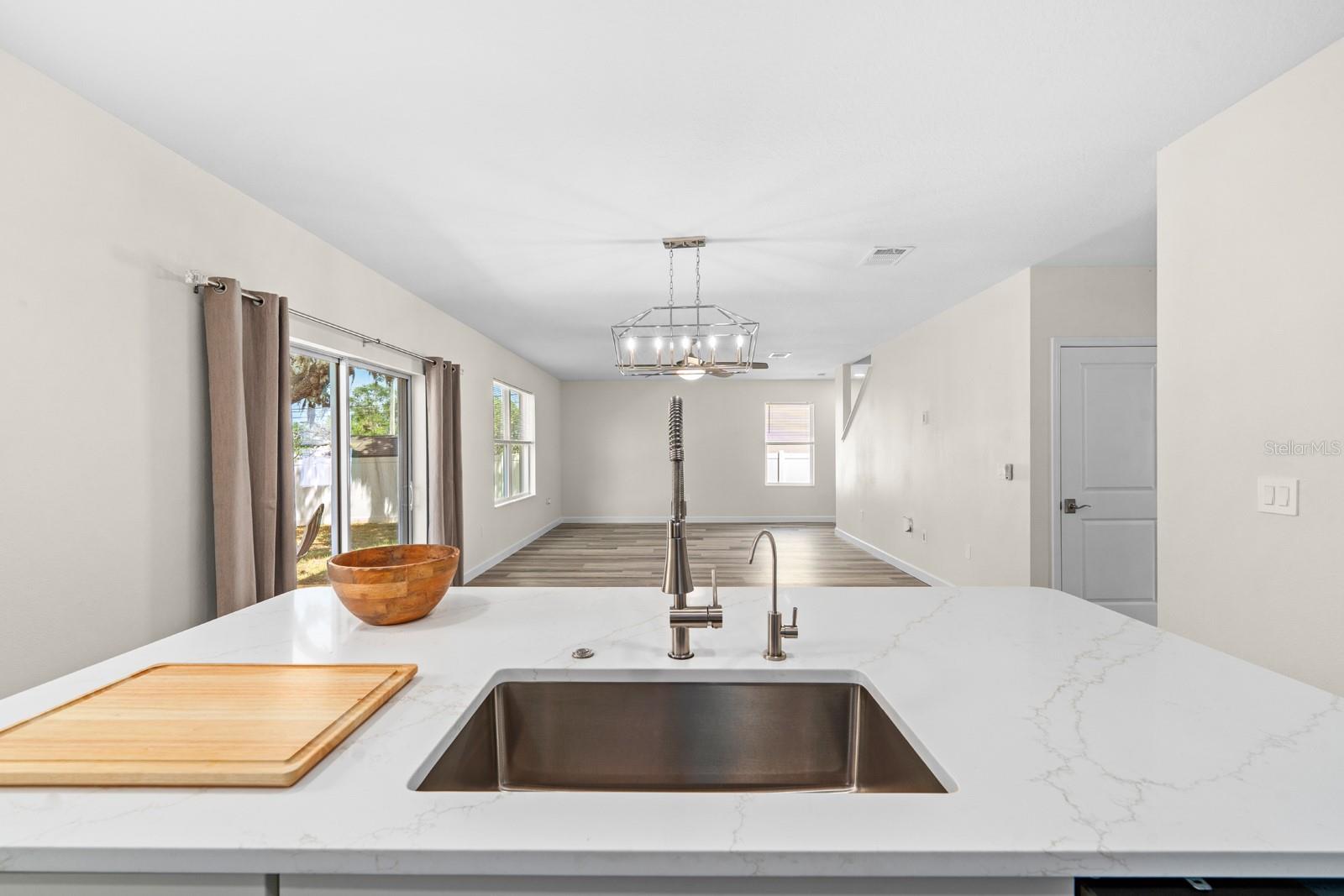 Quartz countertops, new sink and faucet, new garbage disposal, and a new water dispenser with a water filtration system under the sink.