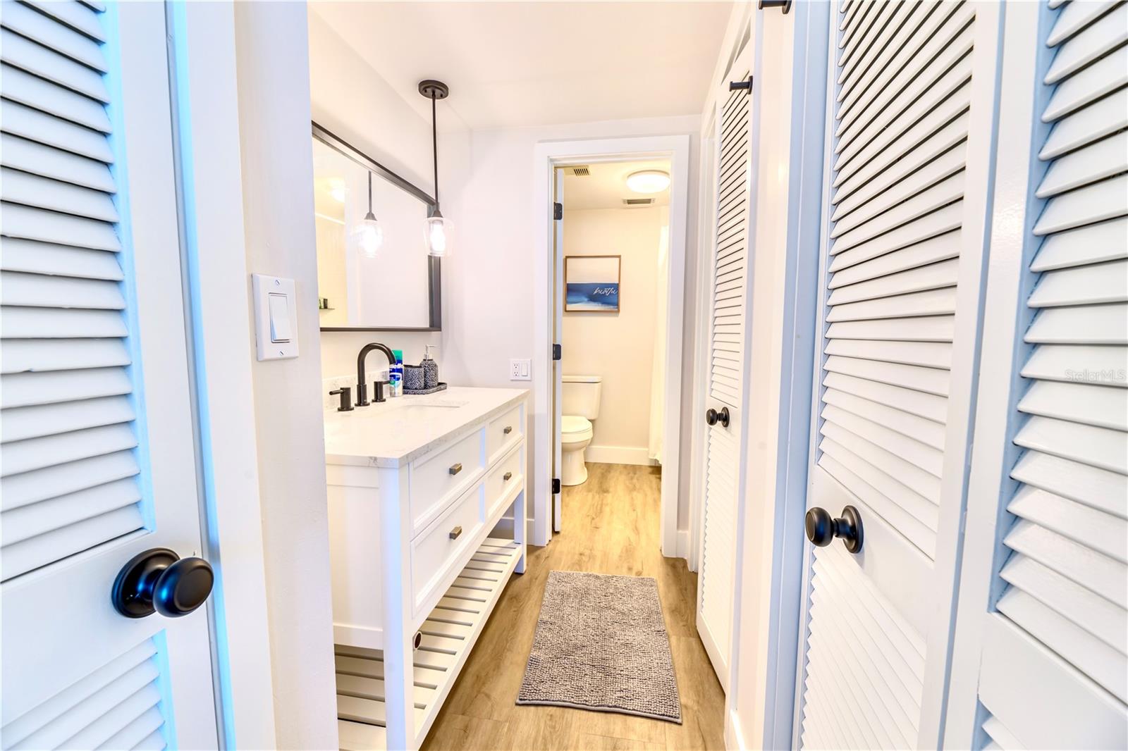 Left to Right:  Towel Closet, Single Vanity with Quartz countertops, Toilet & Shower tub, 2 closets on right
