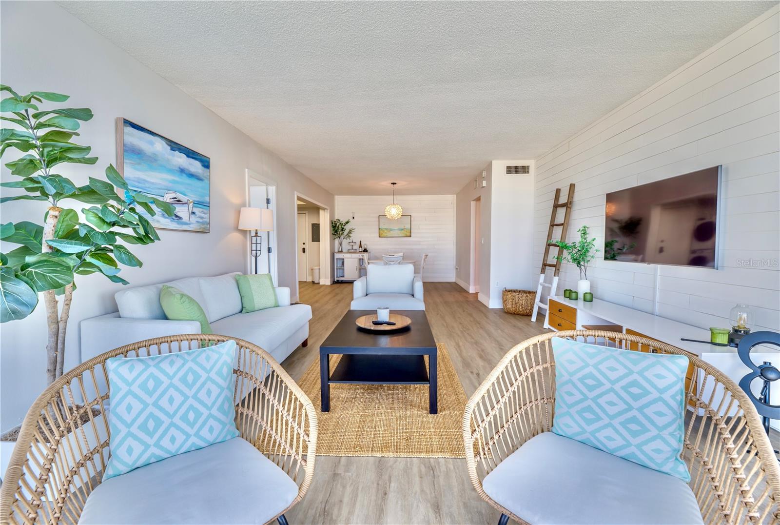 Living Room view opposite view. Left to Right: 2nd Bedroom entry, Kitchen, Dining,  and Hallway to Front Door & Primary Bedroom