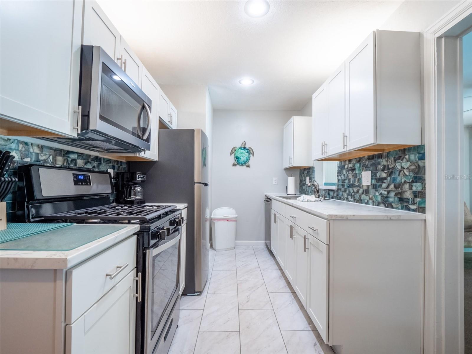 Kitchen featuring white shaker style cabinets