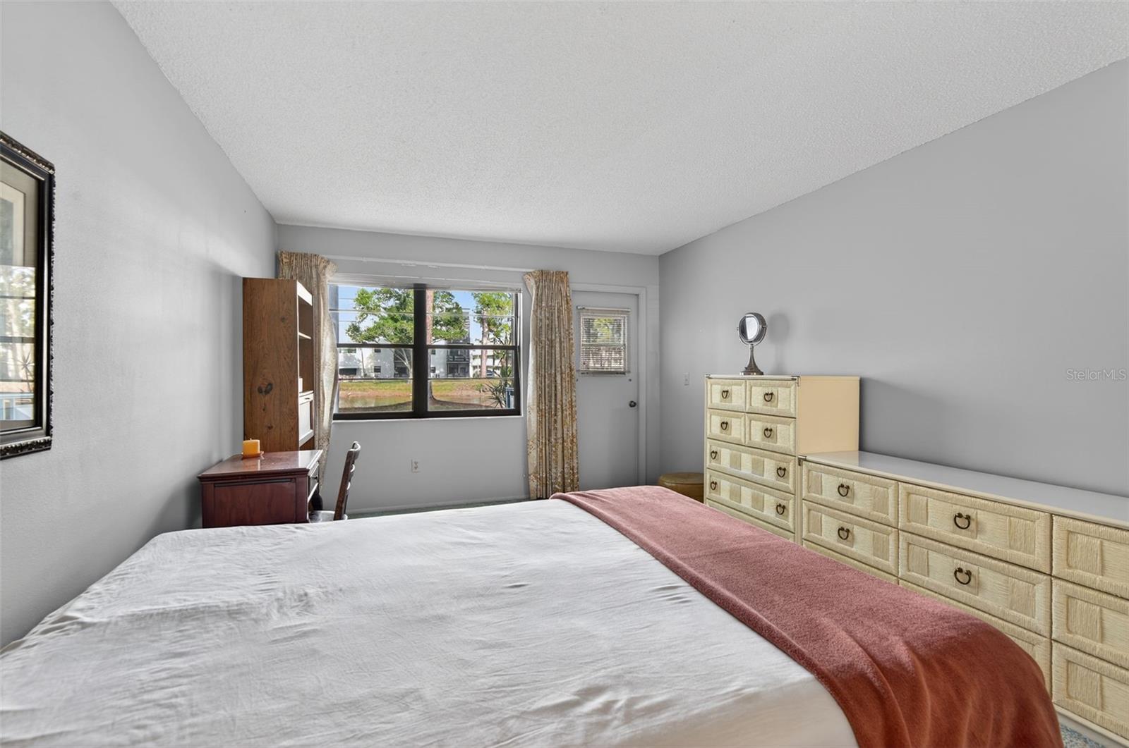 Primary Bedroom with direct access to Screened Lanai facing pond