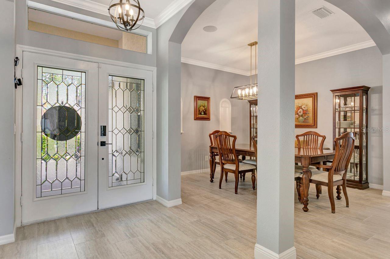 Double Door Glass Entry, Foyer and Formal Dining Room with Column Accents