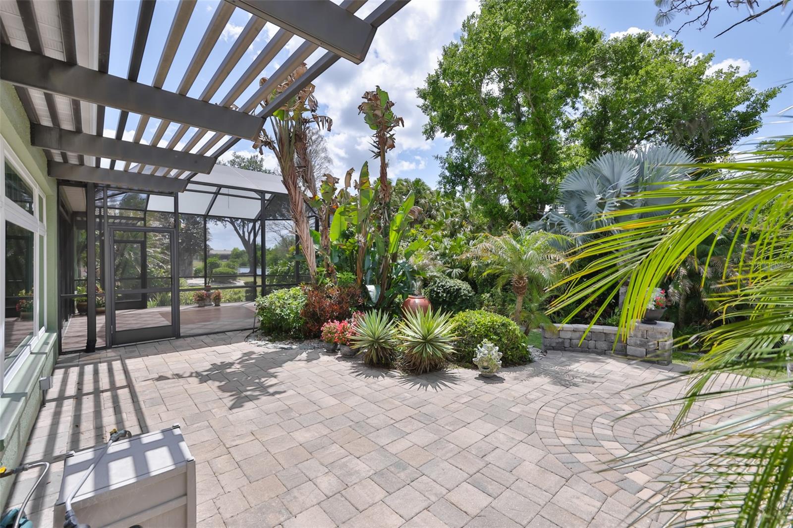 The most exquisite location of the home is the back yard with custom pavered gardens, a fountain, water view and both screened and open air patios.