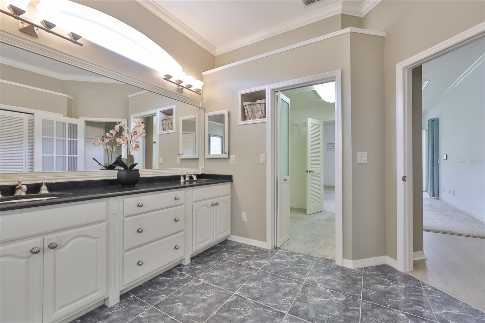 The primary bath has dual sinks, windows for natural sunshine, and lots of drawers for storage.