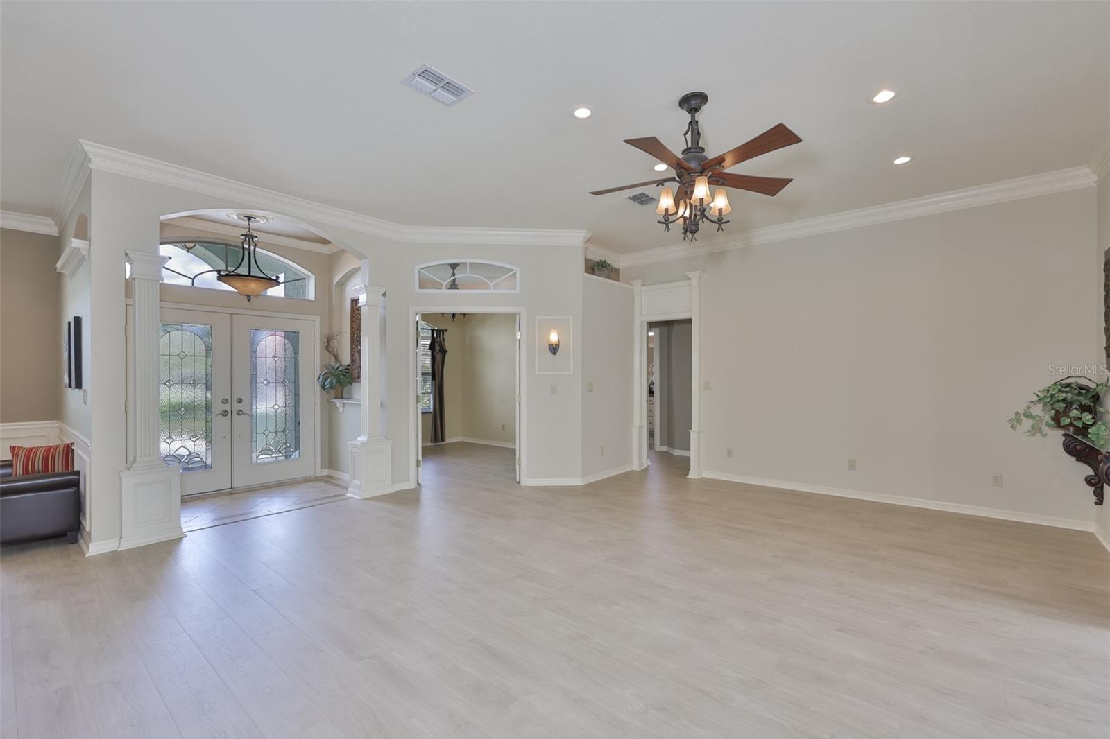 As you walk into the home, the large open floor plan welcomes you.  Double glass doors and a transom allows natural Florida sunshine to filter into the home.  Many architectural features, such as the understated columns at the front door, LIGHTED high shelves for accents and niches built into the walls provide an understated elegance to the home.