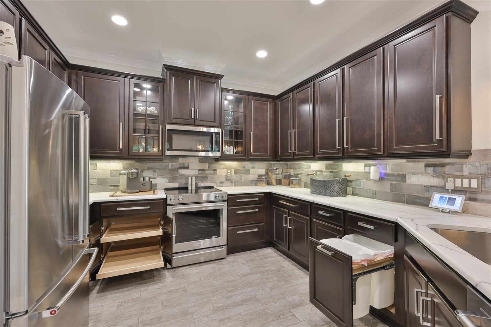 Pull Out shelving, recycle bins and custom backsplash all compliment this beautiful kitchen.