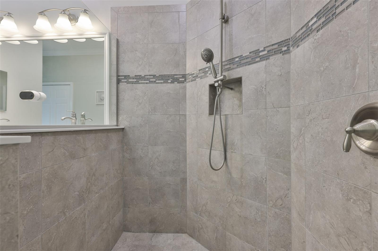 The walk in shower is large with a contempary feel and a 'half' wall for personal privacy.