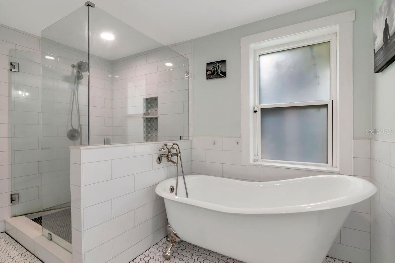 En-Suite Primary Bathroom with Amazing Claw Tub, Window for Light, Large Shower Stall with decorative inset for convenience, recessed lighting, and more!
