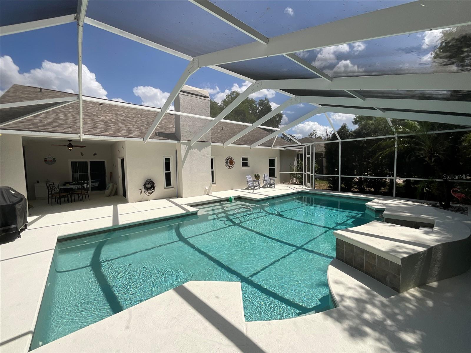 Luxurious long steps and plenty of seating areas, both in and out of the pool on this screened in patio!