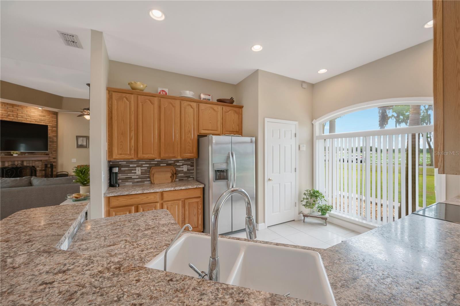 The open kitchen is beautifully highlighted by a large window overlooking the front yard, topped with an elegant arched transom that fills the entire first floor with abundant natural light.