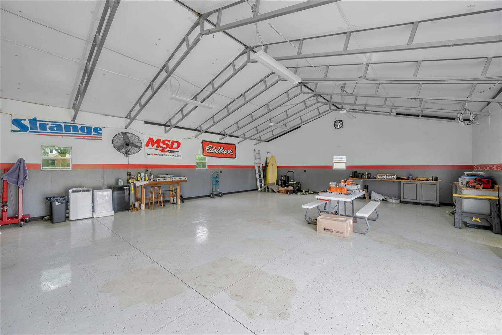 The impressive 48' x 30' detached garage has epoxy flooring, 2 industrial fans, and work tables and cabinets that will convey to the buyer.