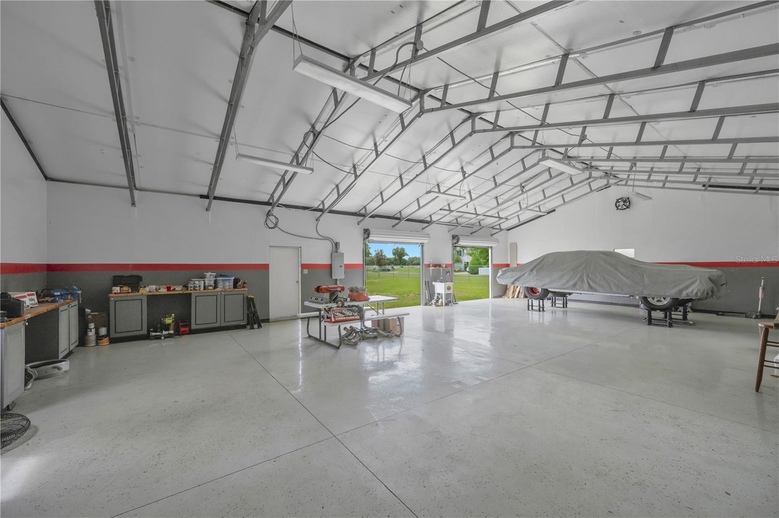 This workspace has two roll-up doors, a separate single-door entry and its own electrical panel and a utility sink with running water. Race car is NOT including with sale of property!