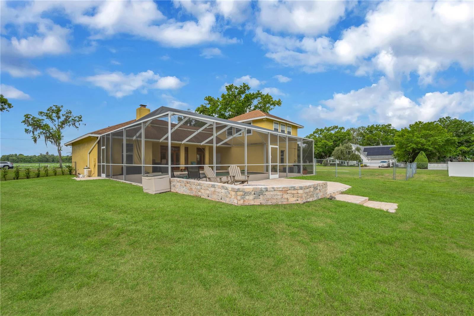 Back view of pool area and patio with firepit.