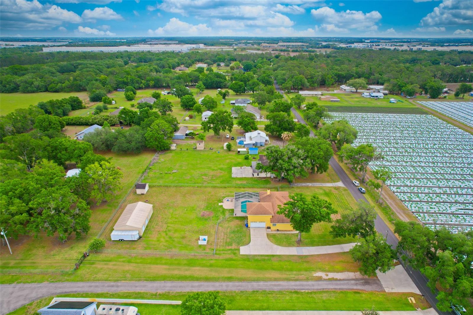 Aerial view of the home showcasing the peaceful surroundings, friendly neighbors, and nearby former strawberry fields now beautifully planted with watermelons.