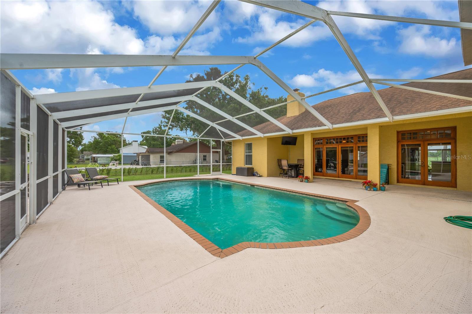 The backyard is designed for enjoying the Florida outdoors, featuring a large screened pool with color-changing lighting and an expansive deck - perfect for entertaining family and friends.