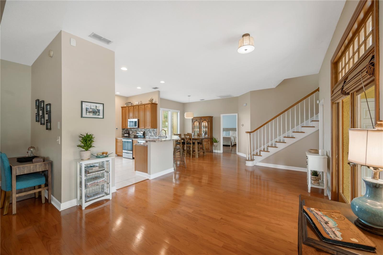The great room features beautiful wood floors, soaring ceilings, lots of natural light from the double French doors and large windows and a wide staircase leading to the second-floor bonus loft.