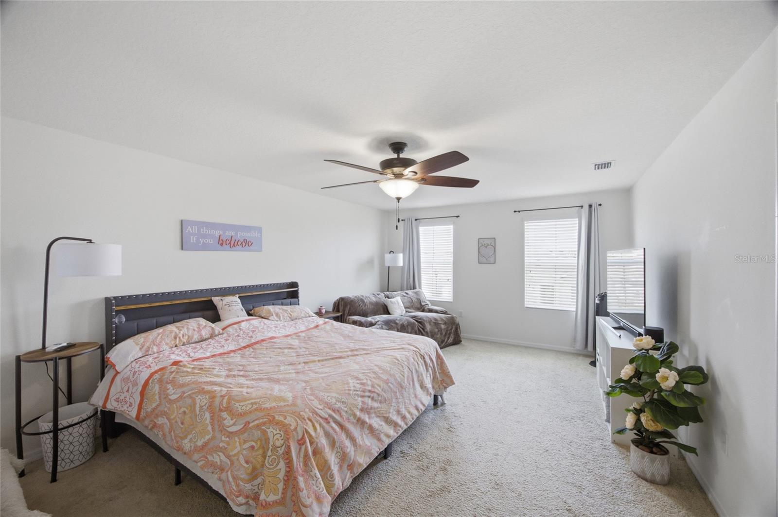large primary suite on 2nd floor with ceiling fan and 2 East facing windows to watch the sunrise