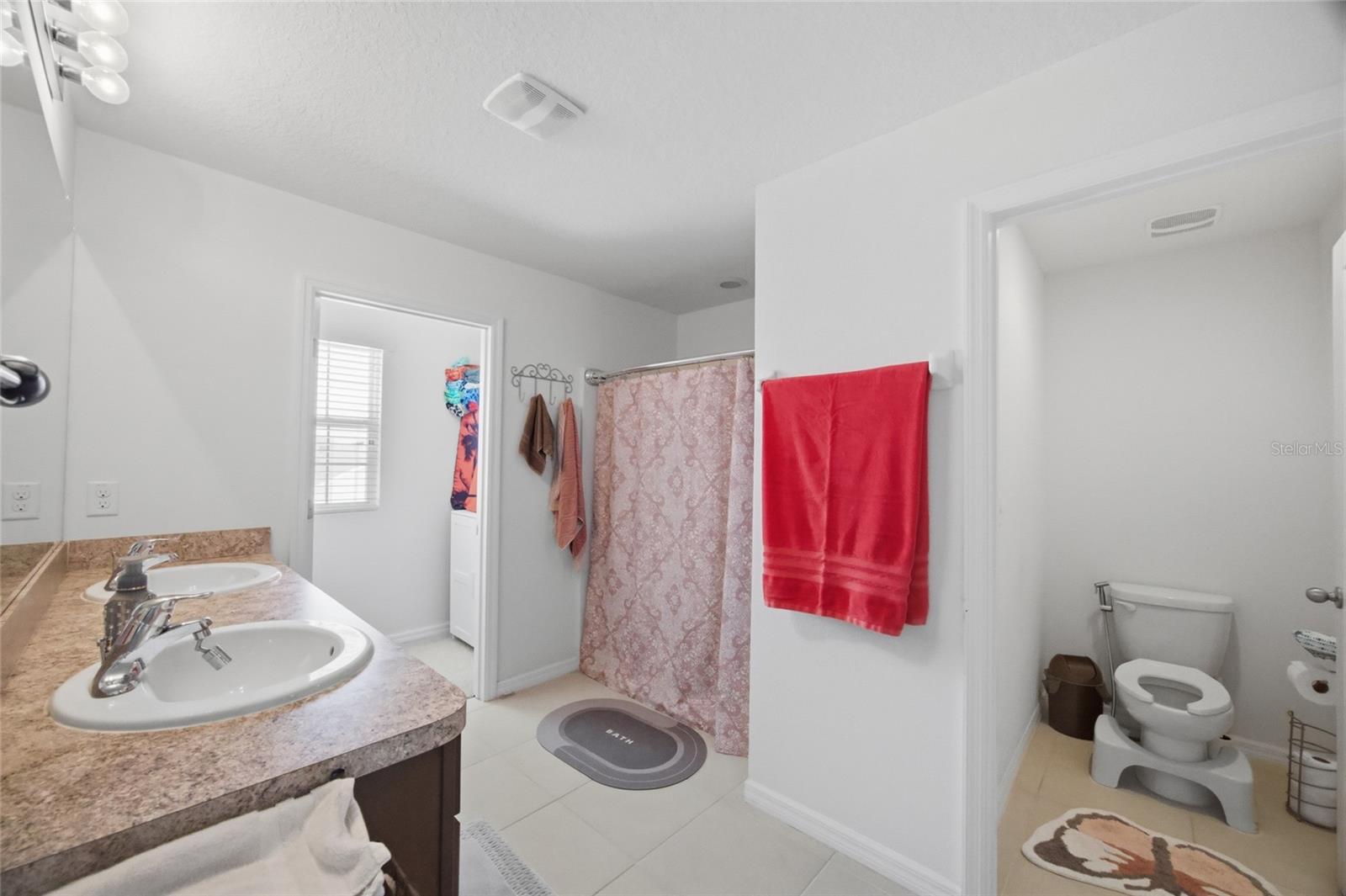 Primary bathroom with shower, commode closet, dual sinks and 2 walk-in closets