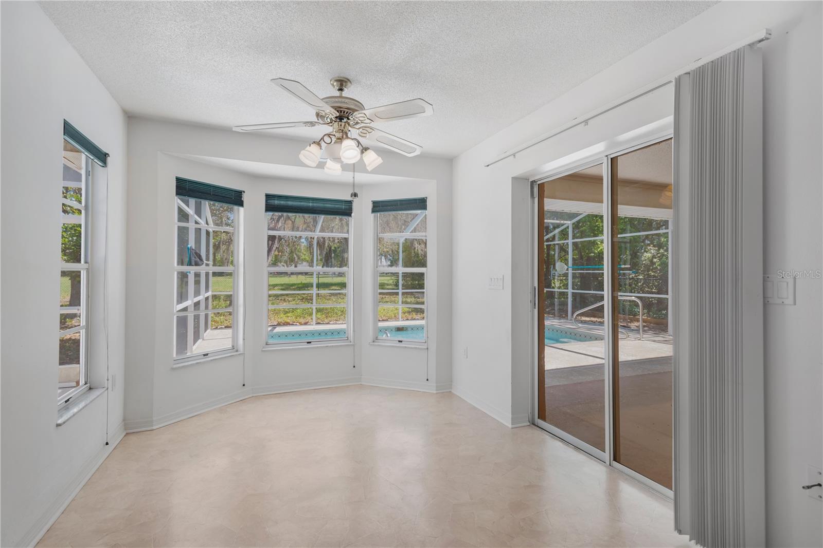 Eat-in kitchen for informal dining offers an abundance of natural light from all angles.  Set of sliders lead to covered patio.