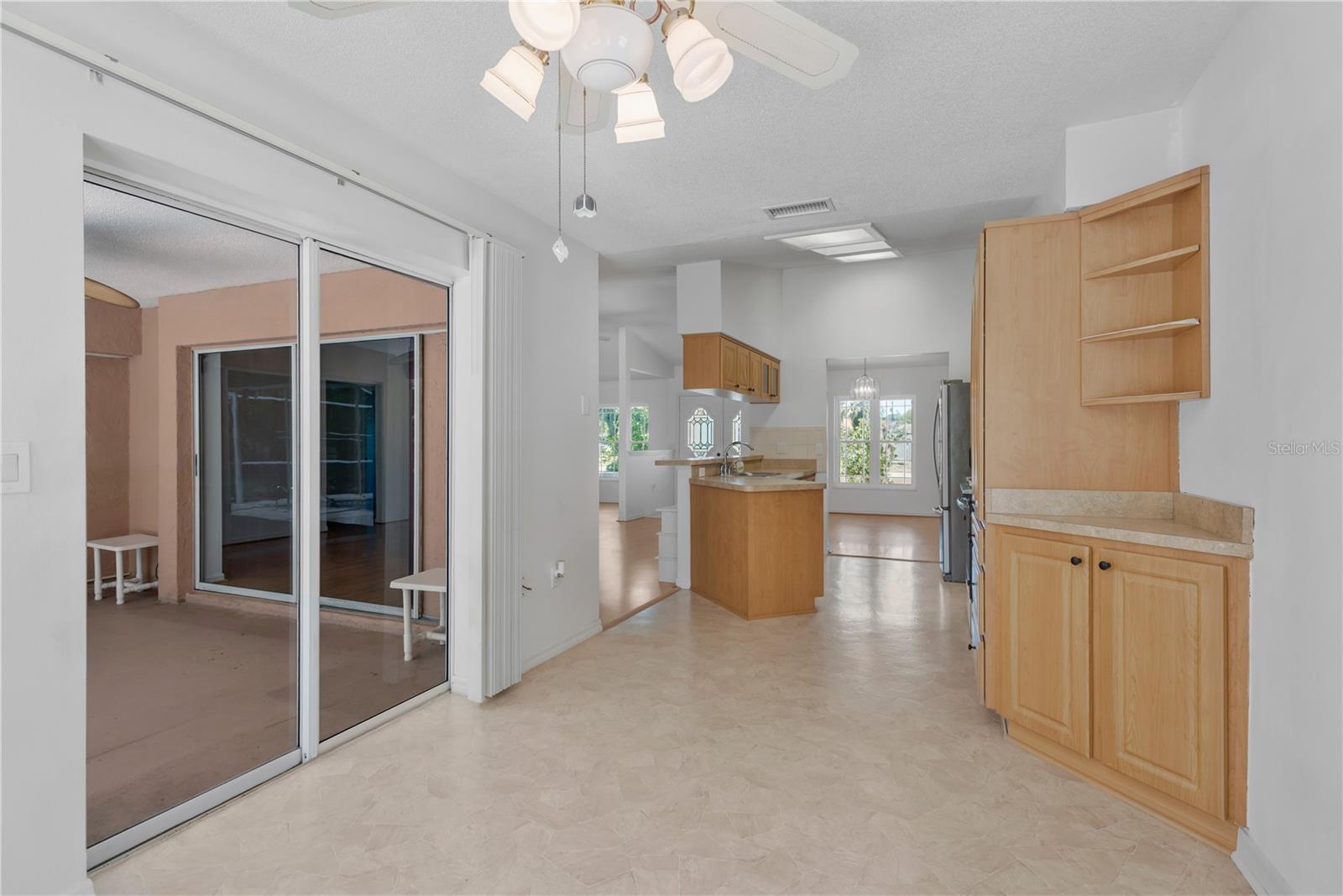 View from eat-in kitchen space to back patio and kitchen to formal dining area.