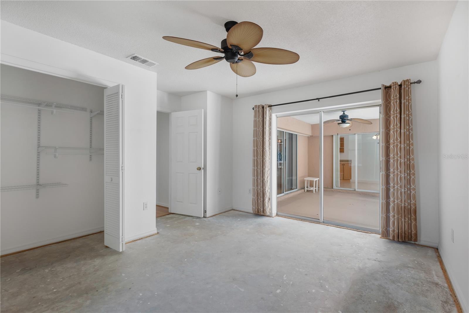 Guest Bedroom 2 offers access sliders to covered patio and pool deck.  Carpet has been removed.